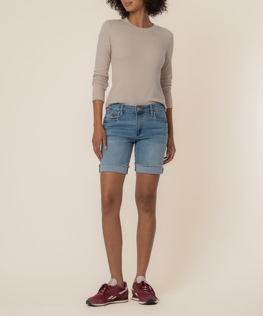 Light blue denim shorts with cuffed hems and a mid-rise fit, paired with a beige long-sleeve top.