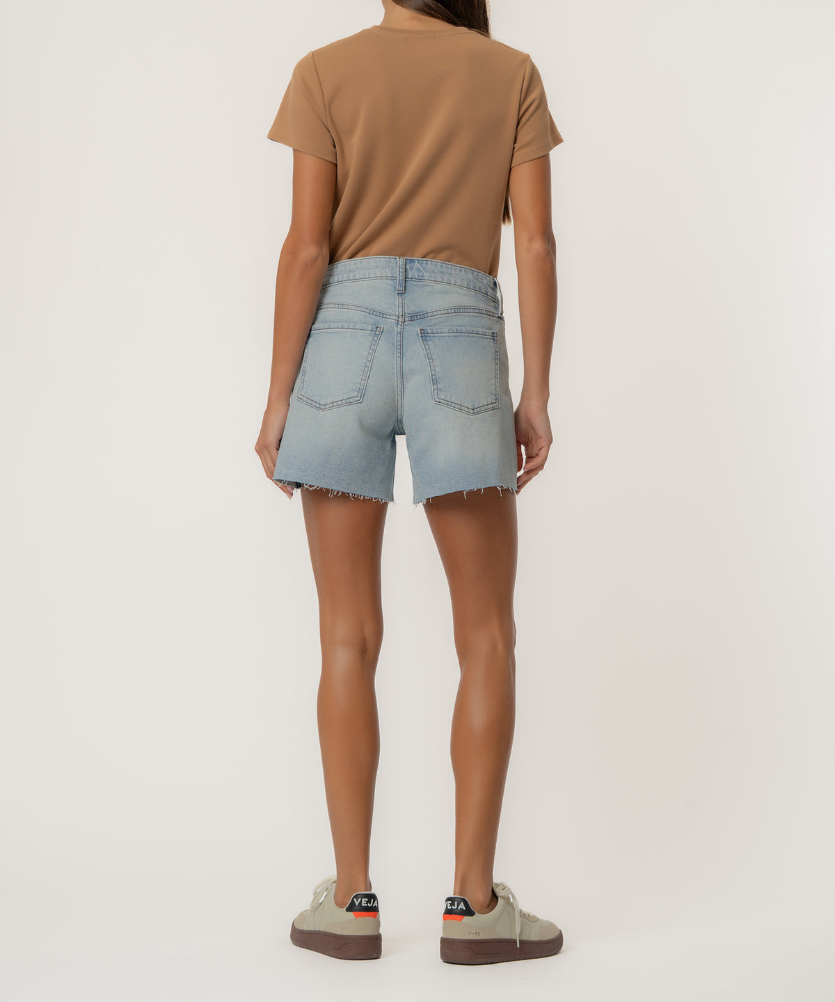 Light wash denim shorts with high rise waist and frayed hem, shown from back.