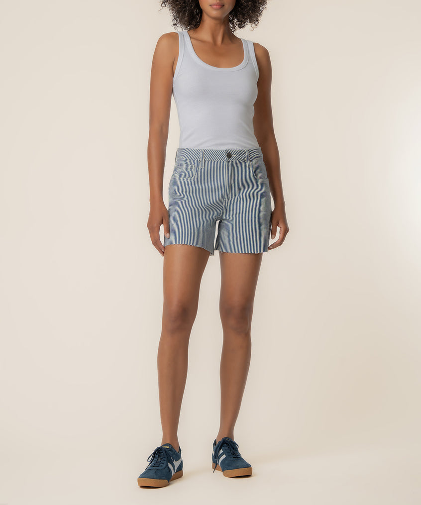 Woman wearing light blue tank top and navy/ivory striped high-rise shorts.