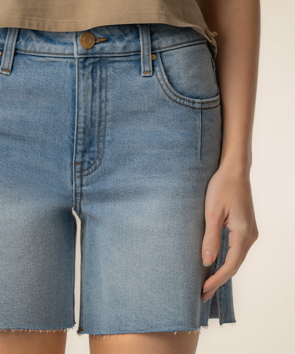 Light blue denim shorts with high waistband, front pockets, and raw frayed hem.