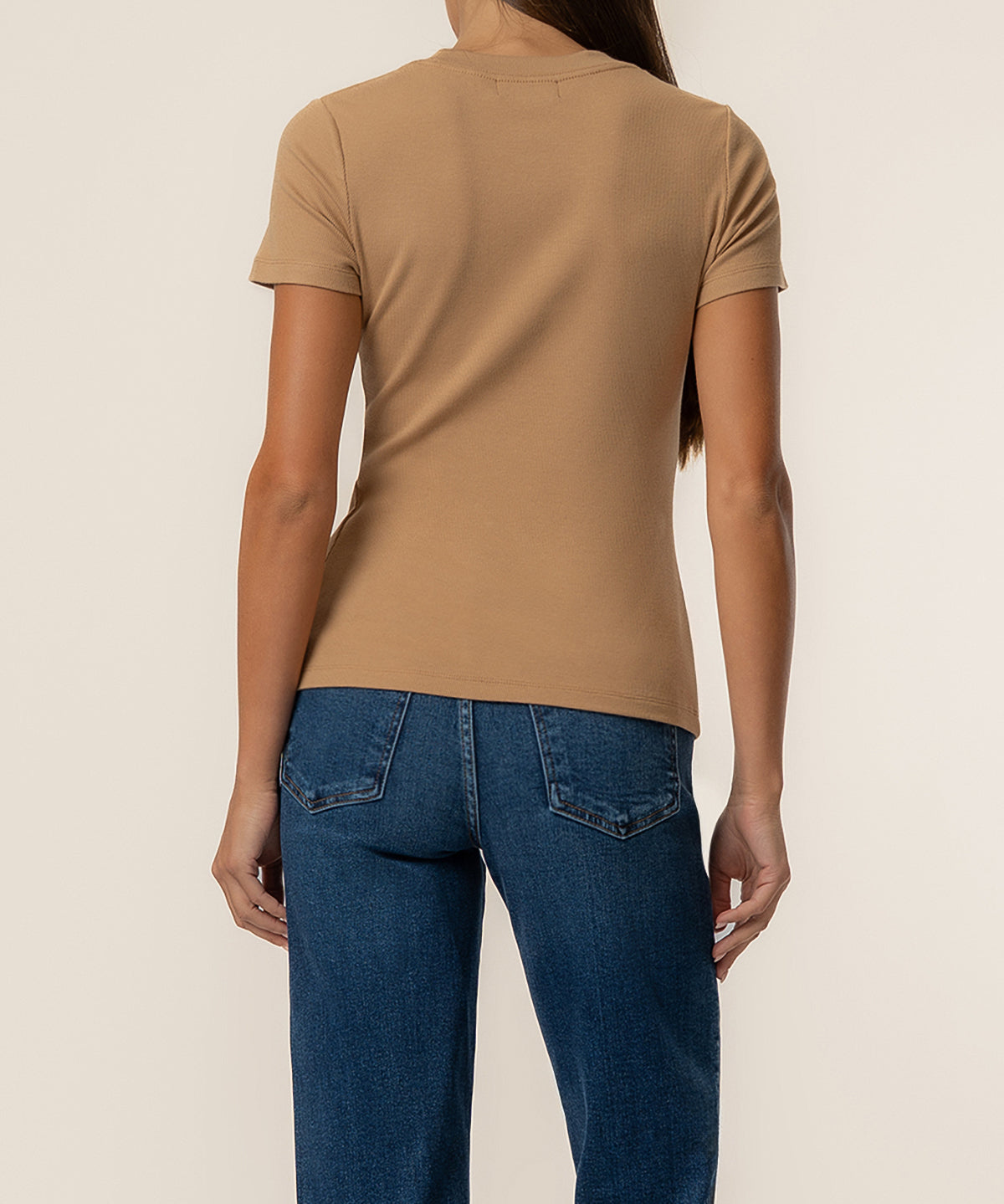 Camel-colored ribbed short-sleeve top with crew neckline, shown from back on model wearing dark blue jeans.