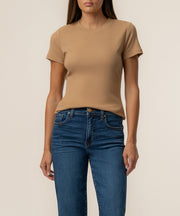 Camel-colored short-sleeve ribbed crew neck top on model wearing dark blue jeans.