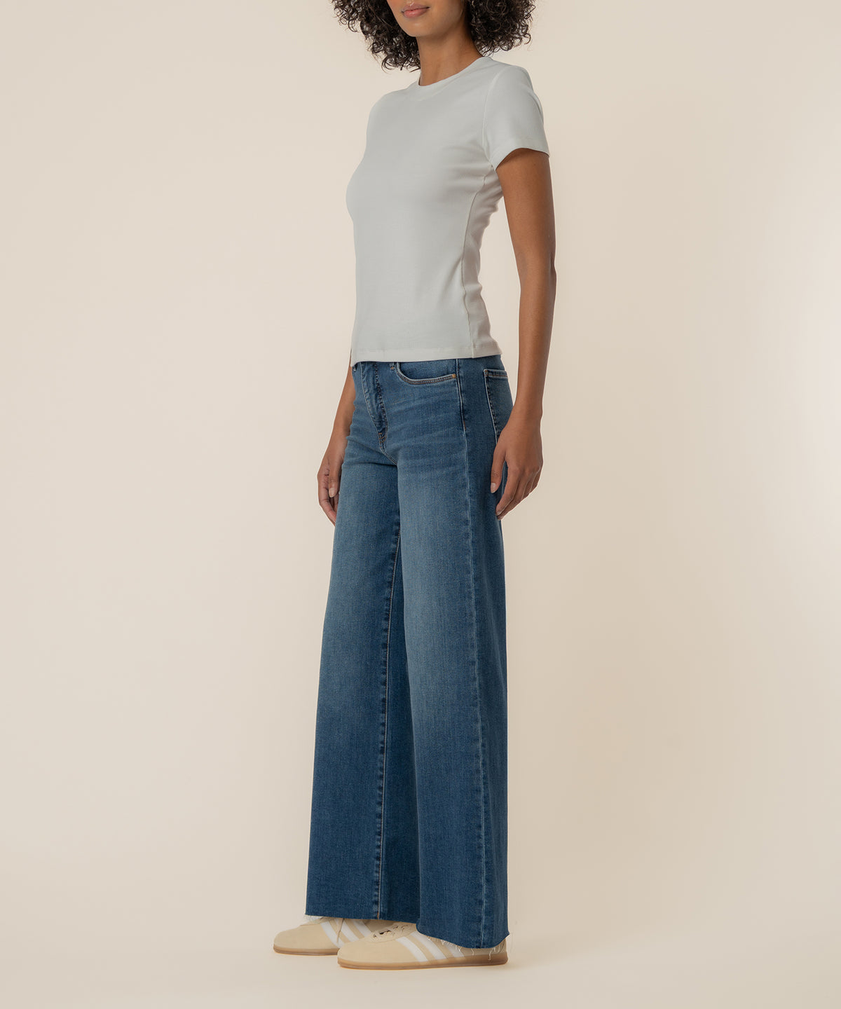 White ribbed short-sleeve crew neck top on model wearing blue jeans.