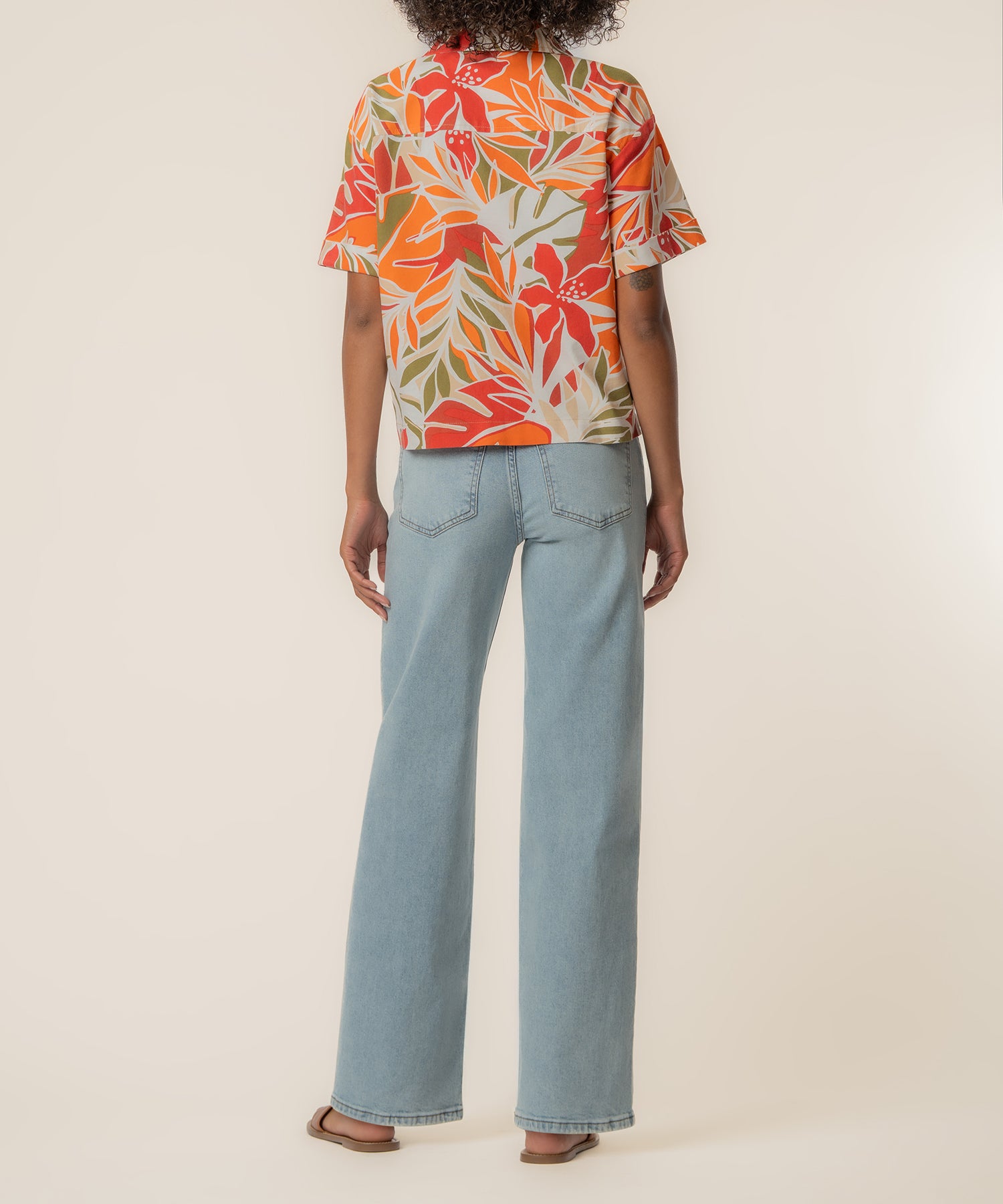 Red and orange floral print linen short-sleeve top with leaf pattern on cream background.