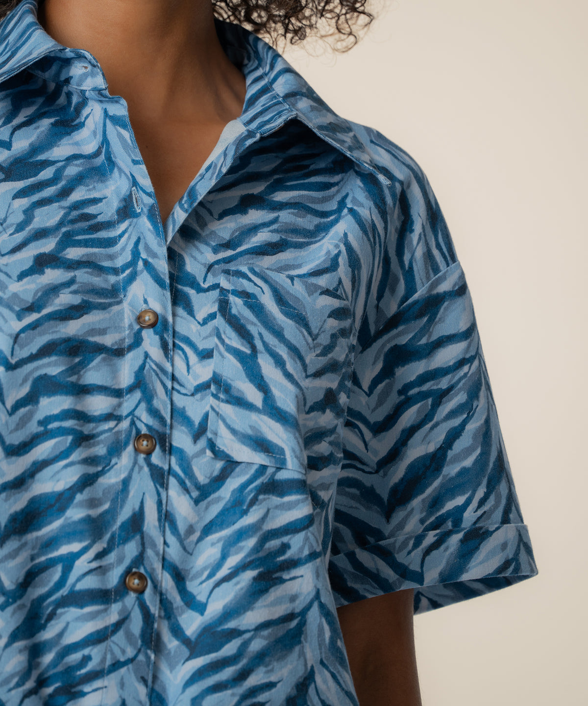 Navy linen top with zebra stripe pattern, collar neckline, and wooden button front closure.