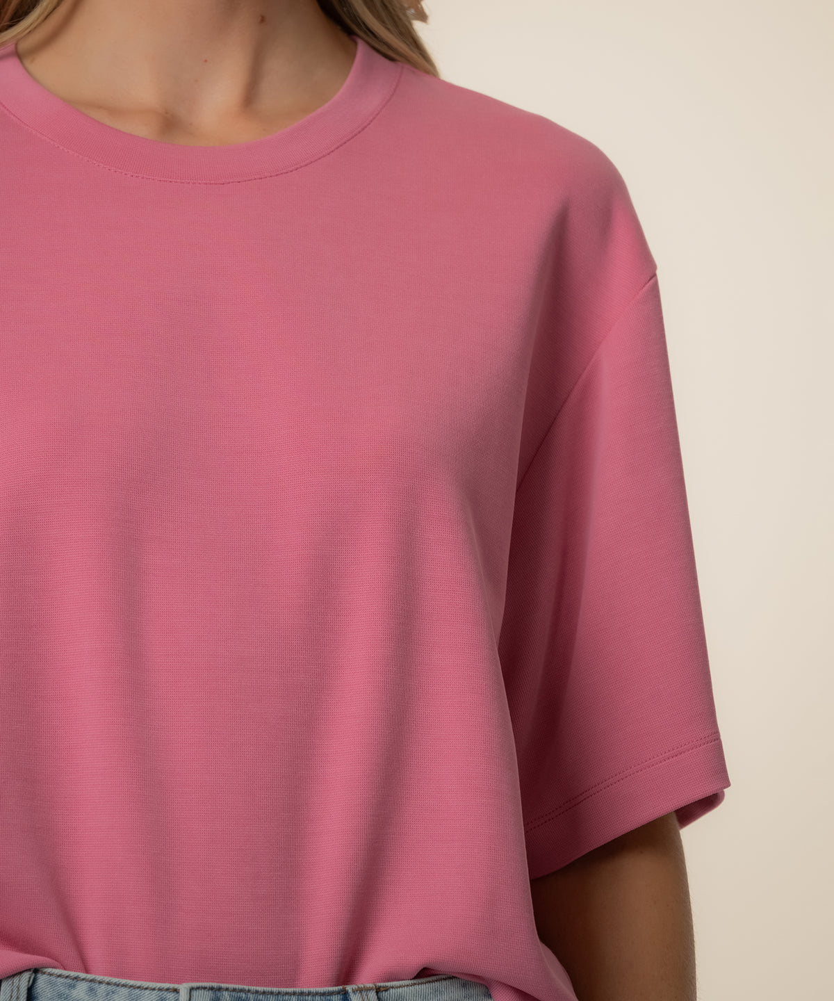 Pink boxy short-sleeve tee with crew neckline on model.