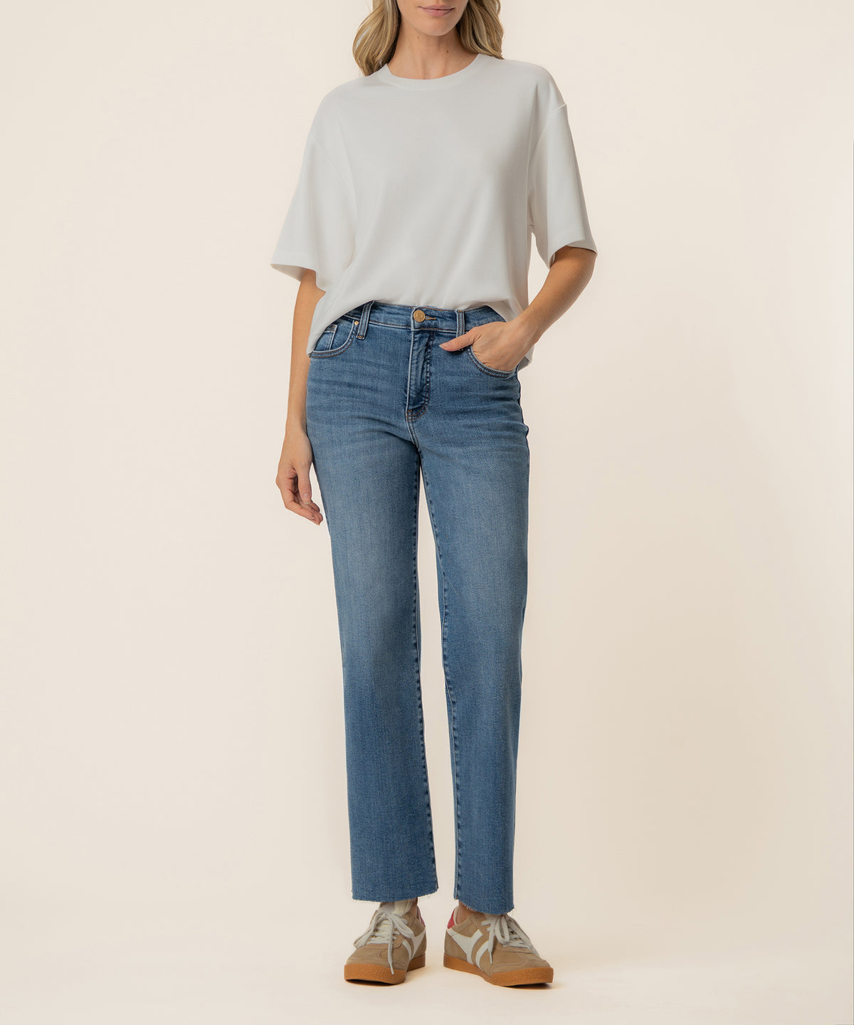 White boxy tee with crew neckline and half sleeves, styled with blue straight-leg jeans.