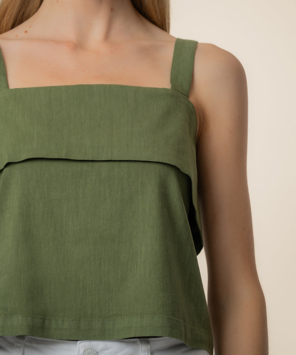 Olive linen tank top with square neckline and horizontal seam detail across the chest.